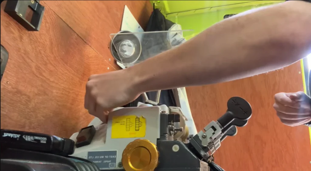 Hands cutting a key on a key cutting machine
