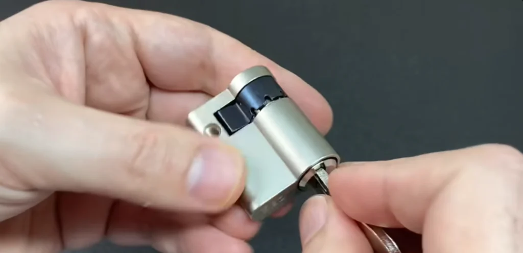 Hands holding a brass lock cylinder